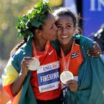 Women's race winner Firehiwot Dado, left, of Ethiopia, gives a kiss on the cheek to second-place winner Buzunesh Deba